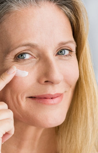 wrinkle-free elderly women applying luxurious anti-aging cream